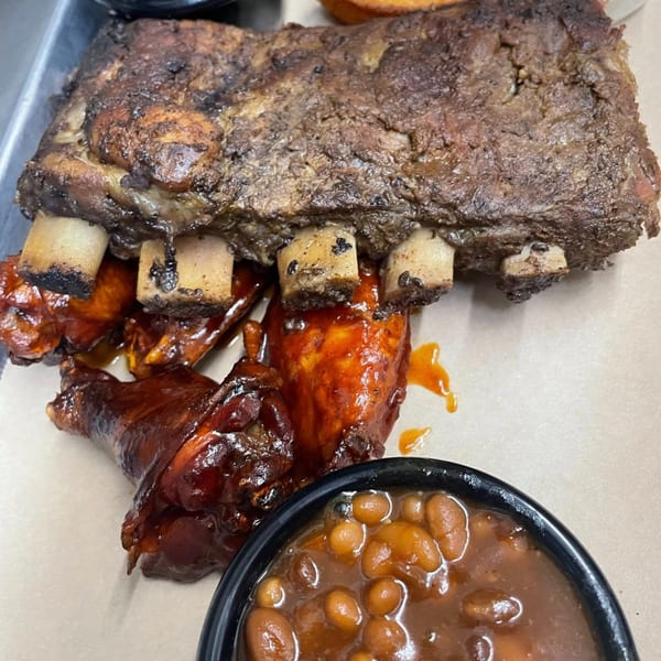 Heintzelman's BBQ Pit ribs and chicken wings with a side of baked beans.